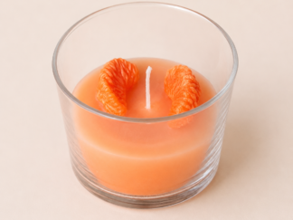 Vela artesanal naranja con detalle de nueces